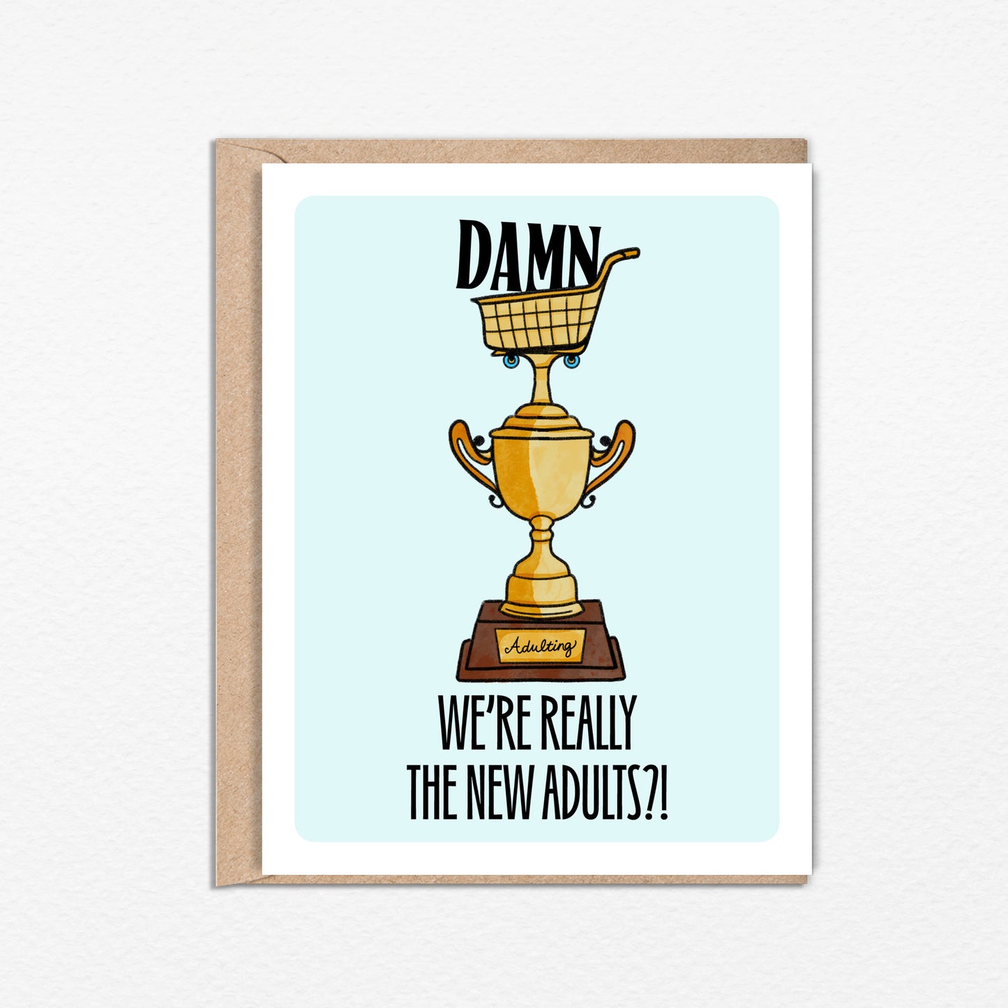 4.25 x 5.5” A2 size card illustration of gold grocery shopping cart trophy, light blue background. The text reads, "Damn We’re Really the New Adults". Blank inside. Black Woman Owned.