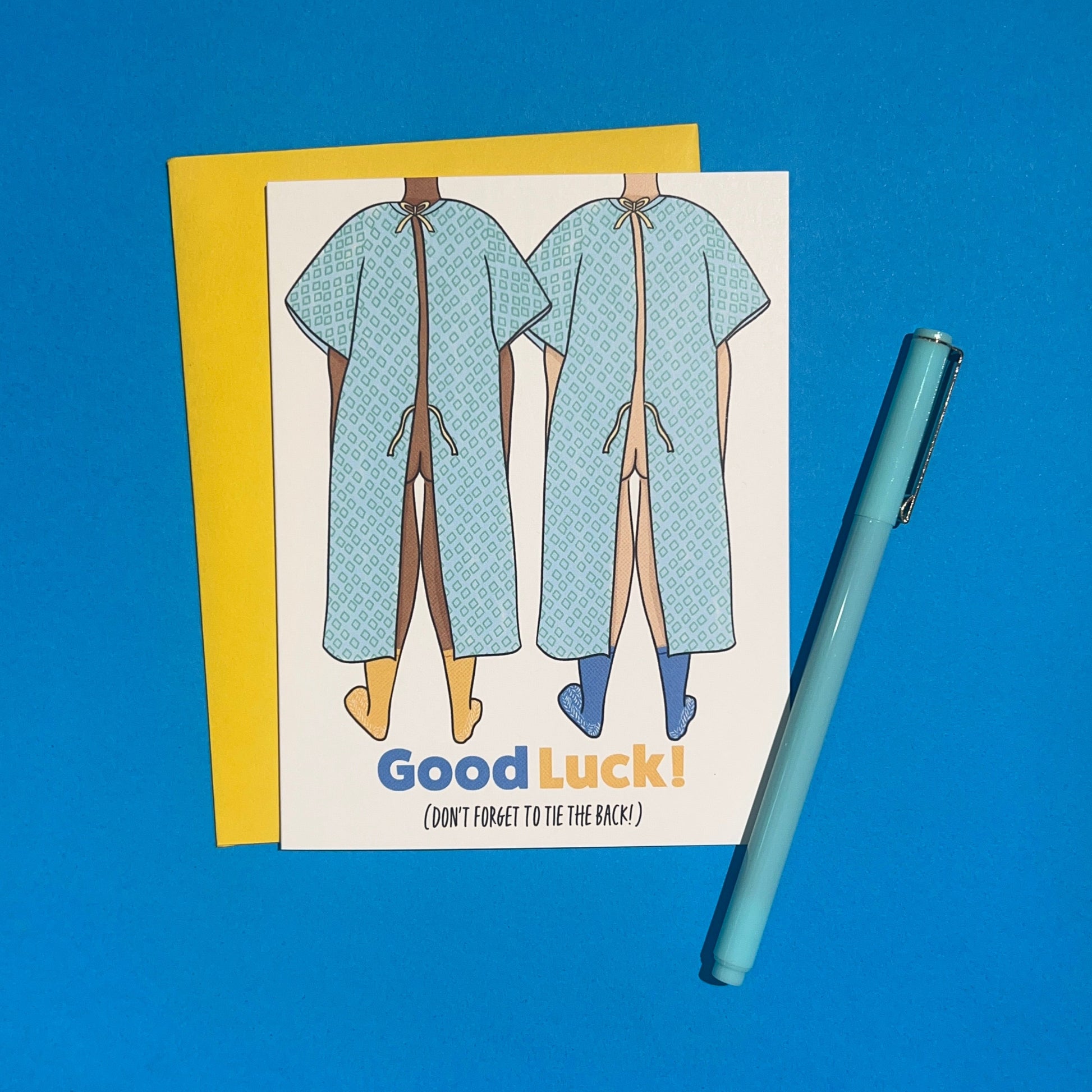 Good luck On Surgery Get Well Soon 4.25 x 5.5” A2 size card illustration of two people wearing hospital gowns with the bottom tie open. The text reads, "Good Luck (Don’t Forget to Tie the Back)". Blank inside. Black Woman Owned.