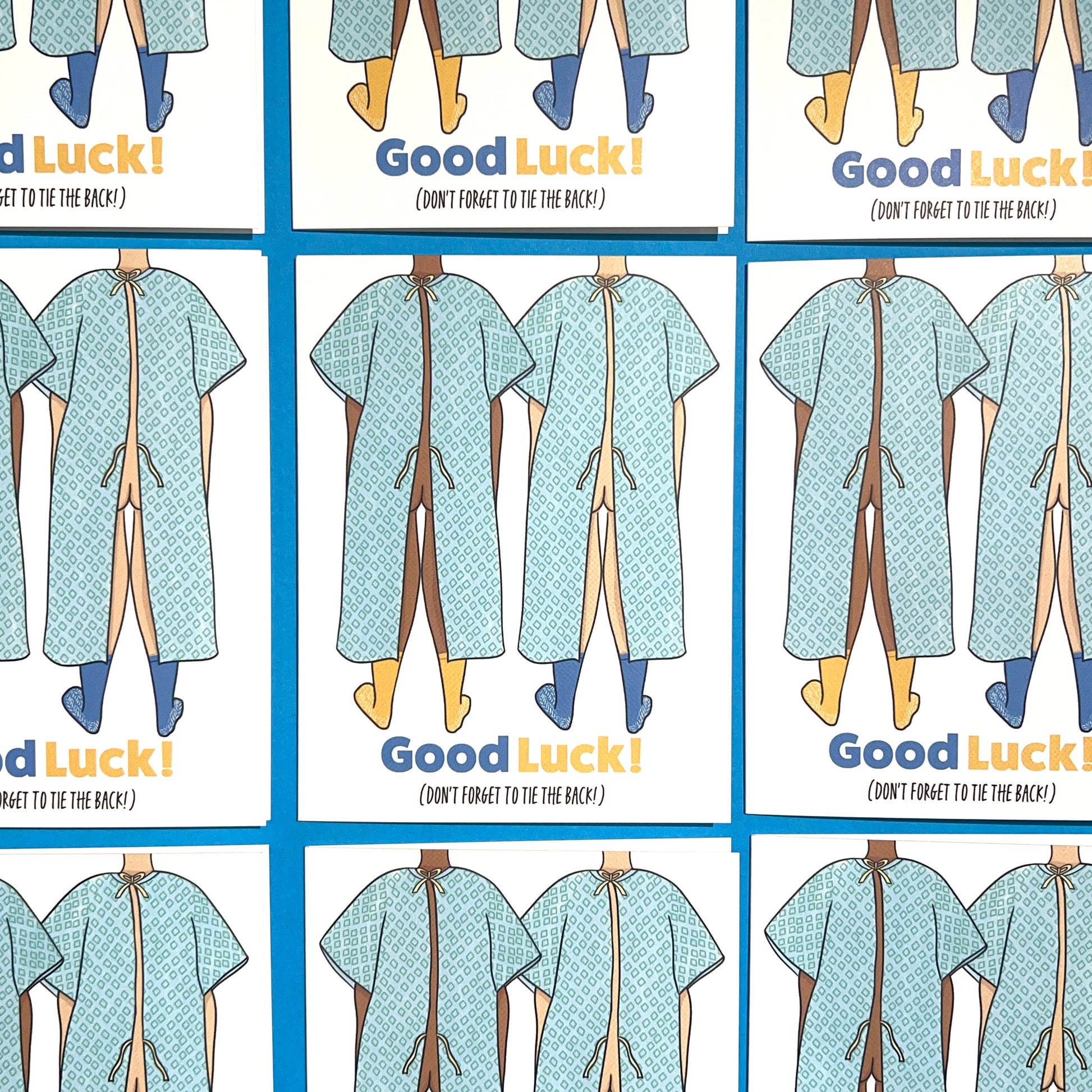 Good luck On Surgery Get Well Soon 4.25 x 5.5” A2 size card illustration of two people wearing hospital gowns with the bottom tie open. The text reads, "Good Luck (Don’t Forget to Tie the Back)". Blank inside. Black Woman Owned.
