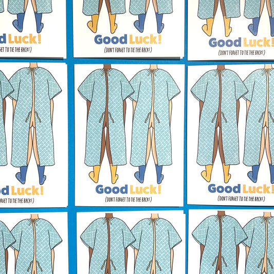 Good luck On Surgery Get Well Soon 4.25 x 5.5” A2 size card illustration of two people wearing hospital gowns with the bottom tie open. The text reads, "Good Luck (Don’t Forget to Tie the Back)". Blank inside. Black Woman Owned.