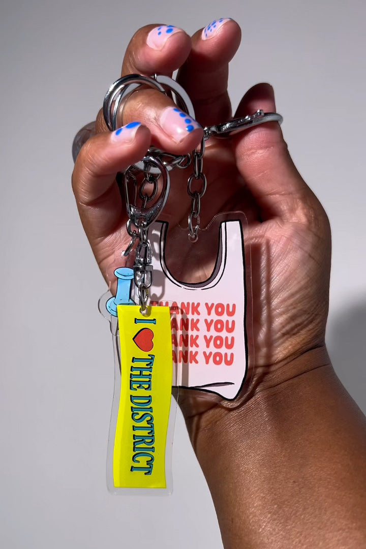 Three double-sided clear acrylic keychains, baby blue push pin, thank you takeout bag, and I Love the District keychains. Individual hooks for a layered look and versatile placement.  