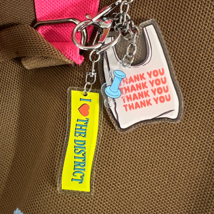 Three double-sided clear acrylic keychains, baby blue push pin, thank you takeout bag, and I Love the District keychains. Individual hooks for a layered look and versatile placement.  