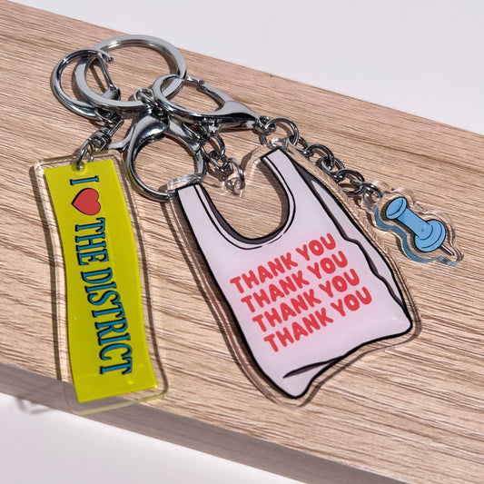 Three double-sided clear acrylic keychains, baby blue push pin, thank you takeout bag, and I Love the District keychains. Individual hooks for a layered look and versatile placement.  