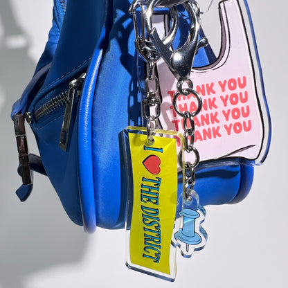 Three double-sided clear acrylic keychains, baby blue push pin, thank you takeout bag, and I Love the District keychains. Individual hooks for a layered look and versatile placement.  