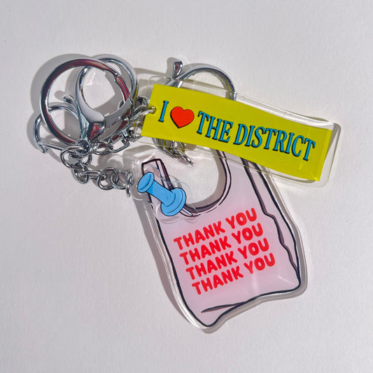 Three double-sided clear acrylic keychains, baby blue push pin, thank you takeout bag, and I Love the District keychains. Individual hooks for a layered look and versatile placement.  