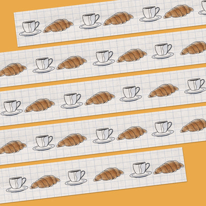 15mm sem-transparent washi tape roll featuring a illustrated coffee cup and saucer and croissant on a light blue grid background. re-adjustable and removable. Perfect for your planner, junk journal, and scrapbook.