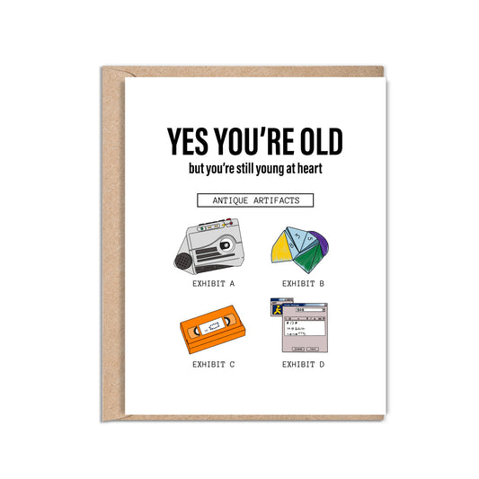 4.25 x 5.5” A2 size funny millennial birthday card with illustrations of a rugrats vhs, AIM screen, audio recorder, and paper fortune teller. The text reads, "Yes you’re old but you’re still young at heart". Message inside included. Black Woman Owned.