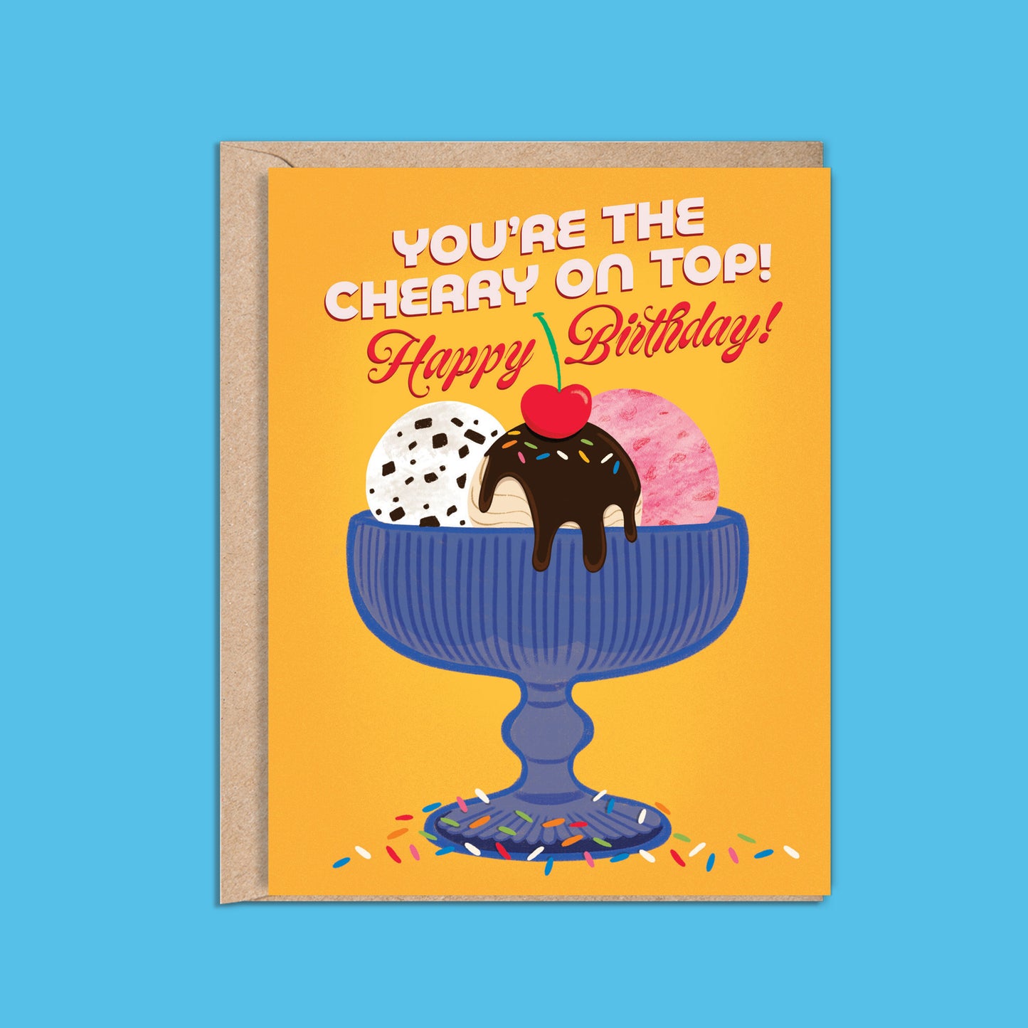 A2 size birthday card featuring blue antique glass ice cream bowl with chocolate chip, strawberry, and fudge salted caramel ice cream illustration on a warm yellow background. “You’re the cherry on top! Happy Birthday” text on the front in white and red. The message inside reads “Happy Birthday!”,. Envelope included.