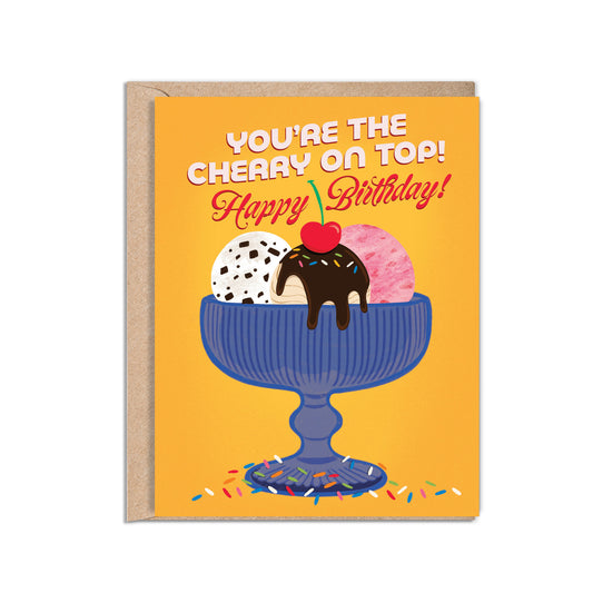 A2 size birthday card featuring blue antique glass ice cream bowl with chocolate chip, strawberry, and fudge salted caramel ice cream illustration on a warm yellow background. “You’re the cherry on top! Happy Birthday” text on the front in white and red. The message inside reads “Happy Birthday!”,. Envelope included.