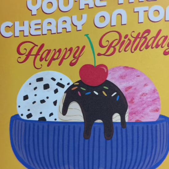 A2 size birthday card featuring blue antique glass ice cream bowl with chocolate chip, strawberry, and fudge salted caramel ice cream illustration on a warm yellow background. “You’re the cherry on top! Happy Birthday” text on the front in white and red. The message inside reads “Happy Birthday!”,. Envelope included.