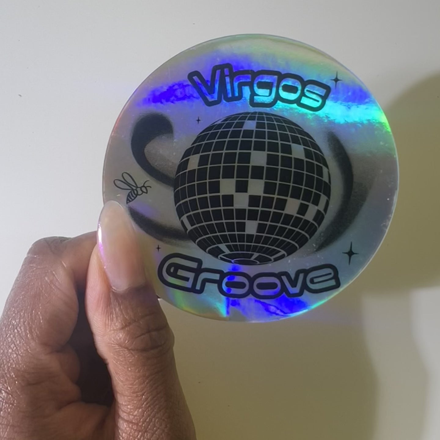 3 x 3” holographic waterproof sticker with a disco ball and the words ‘Virgo’s Groove’. A bee floats around the disco ball symbolizing Beyoncé’s bey-hive.High quality vinyl waterproof and scratch resistant sticker from Goods Made By Digitrillnana. Perfect for laptops, water bottles, phone cases, luggage, journals, and more! Black Woman Owned.