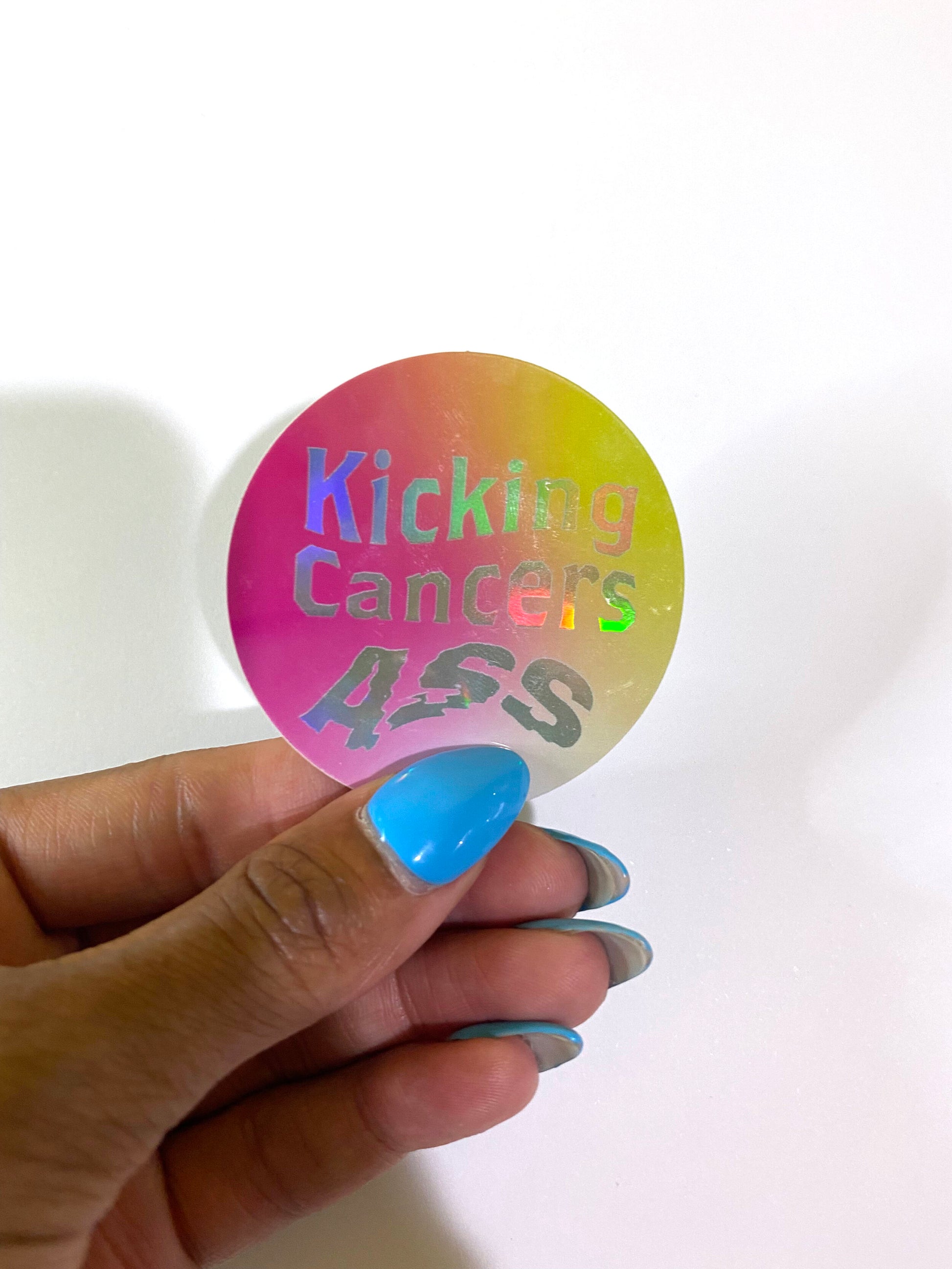 Kicking Cancers Ass holographic high quality vinyl waterproof and scratch resistant sticker from Goods Made By Digitrillnana. Perfect for laptops, water bottles, phone cases, luggage, journals, and more! Black Woman Owned.